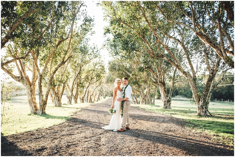 bride and groom under the trees at Puakea ranch
