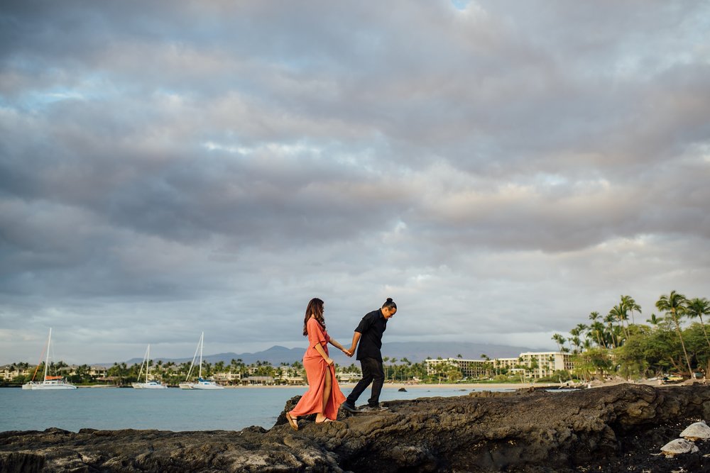 couple holding hands on the lava rocks