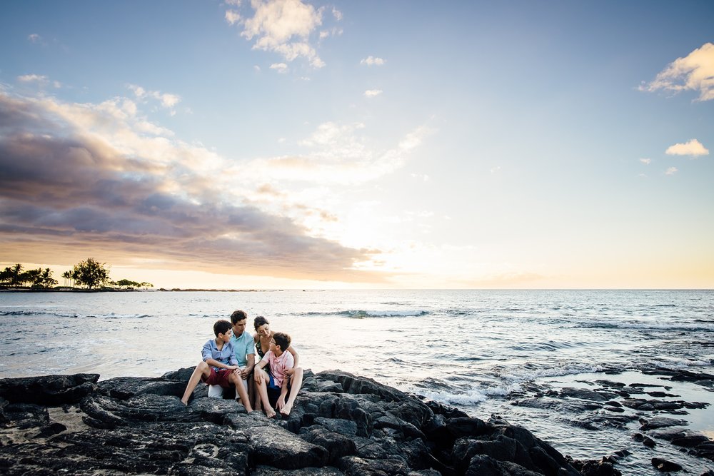 family sitting on the lava rocks