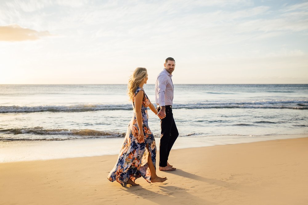 couple walking on the beach beach and ocean during engagement photography in kona hawaii