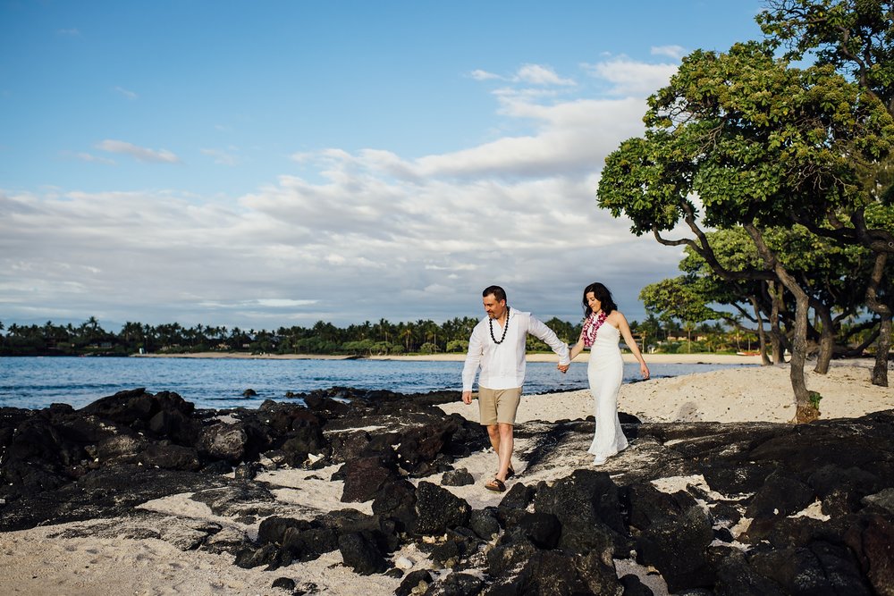 bride and groom walking to lava rocks