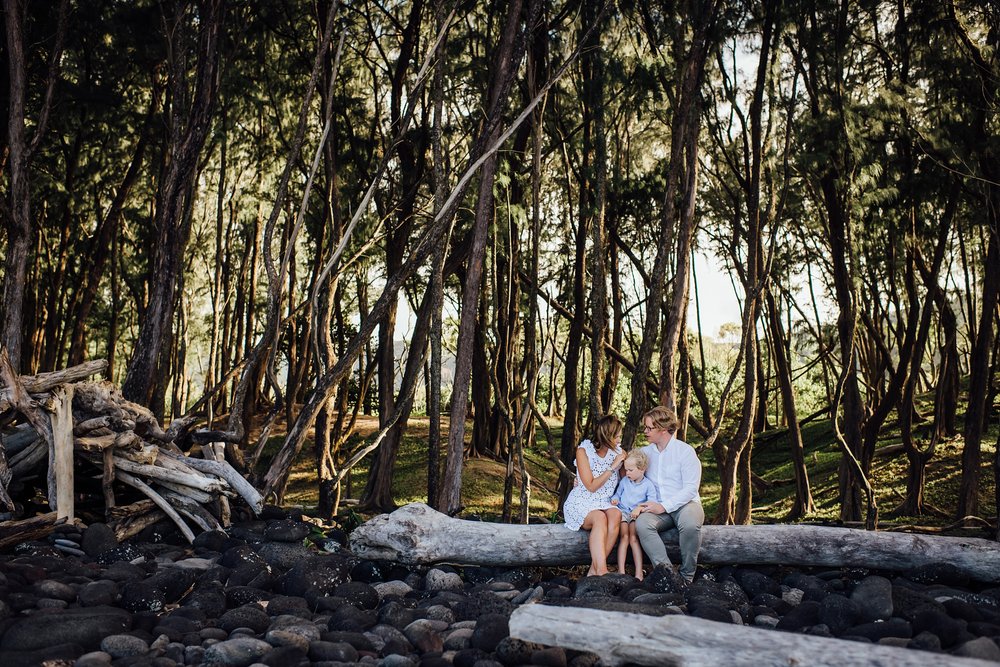 family sitting on a big wood during magical Pololu Valley adventure