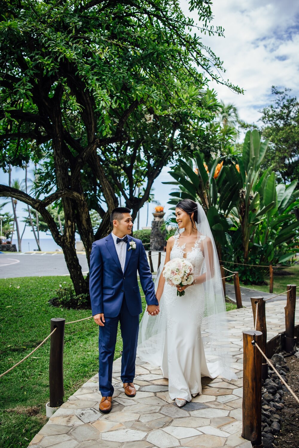 bride and groom holding hands by Kona wedding photographer
