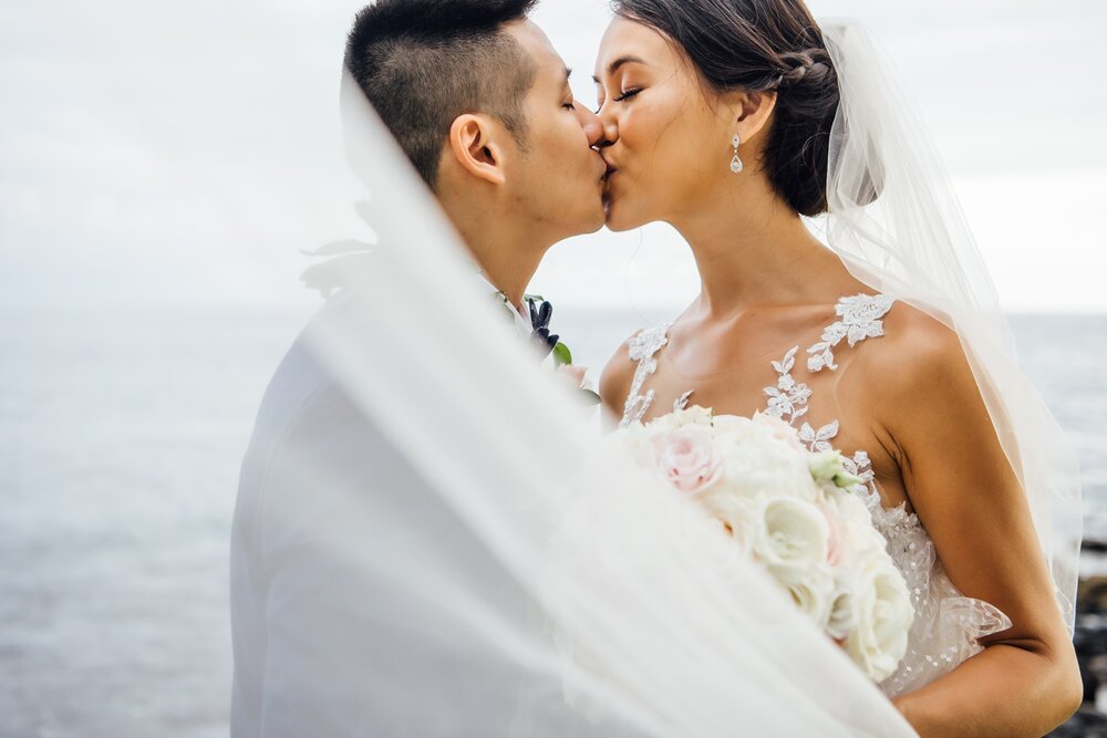 newlyweds kiss under the veil by Kona wedding photographer