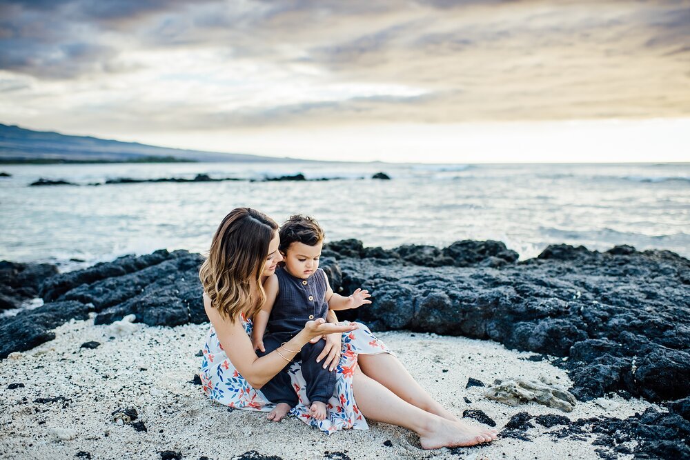 mom and baby sitting on Hilton Waikoloa white sand beach