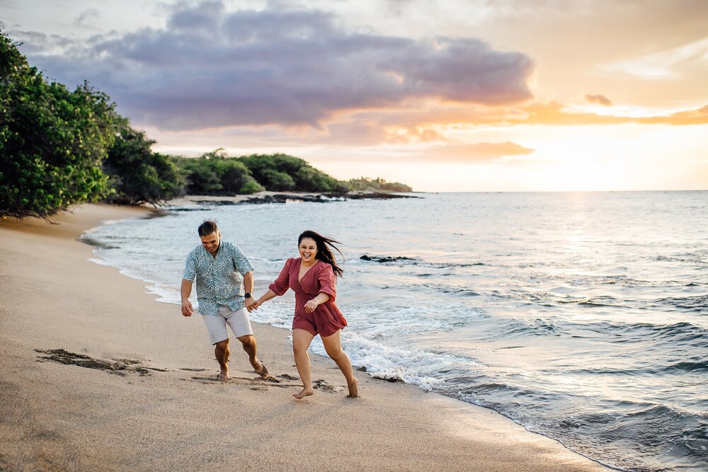 couple frolicking at the beach by Hawaii engagement photographer