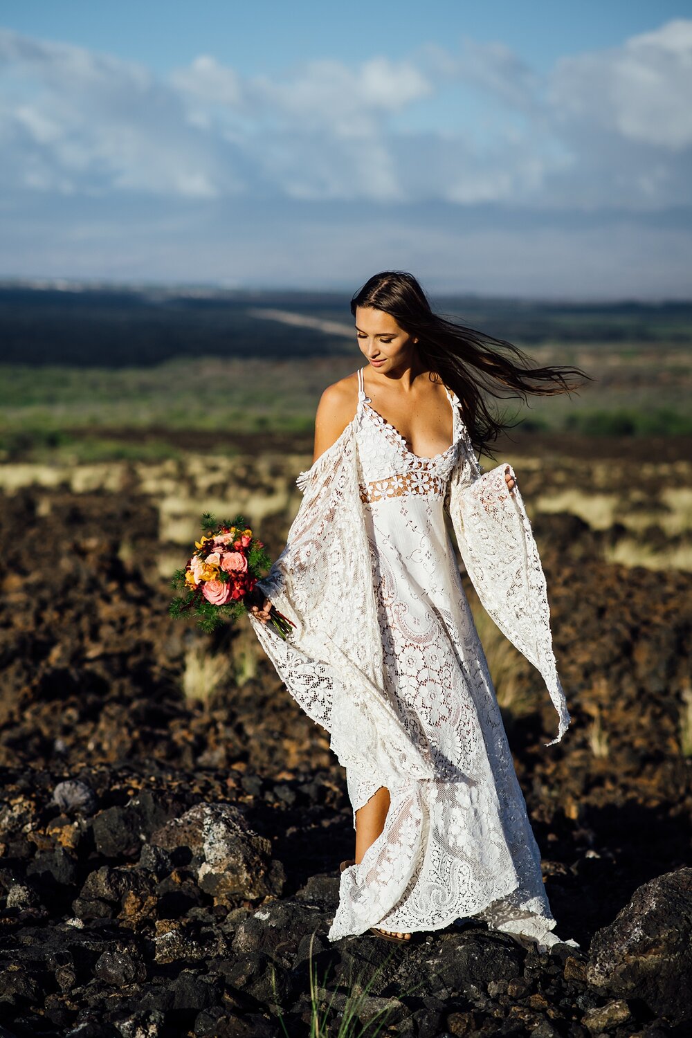 big island bride in a bohemian lace dress on lava rocks