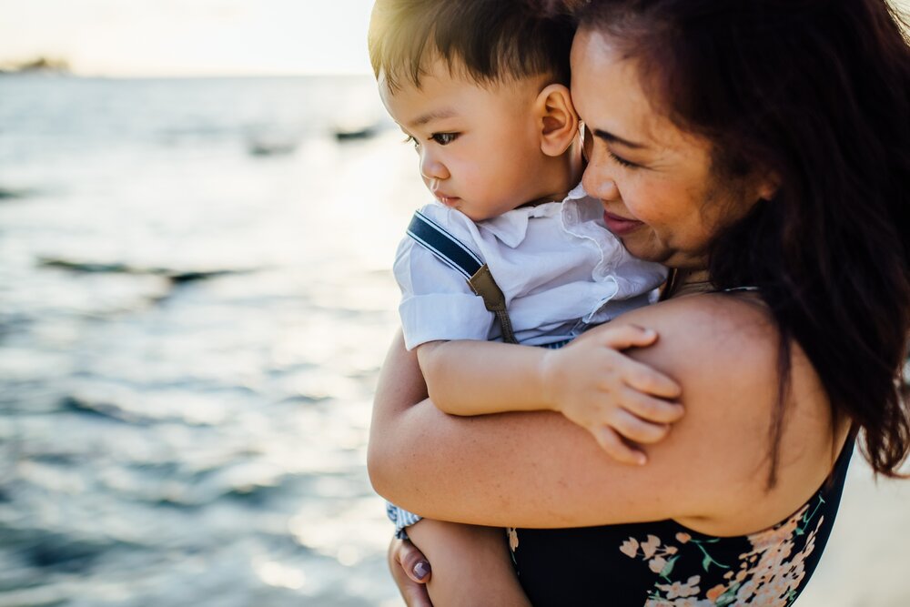 mom sunggling son by Hawaii family photographer