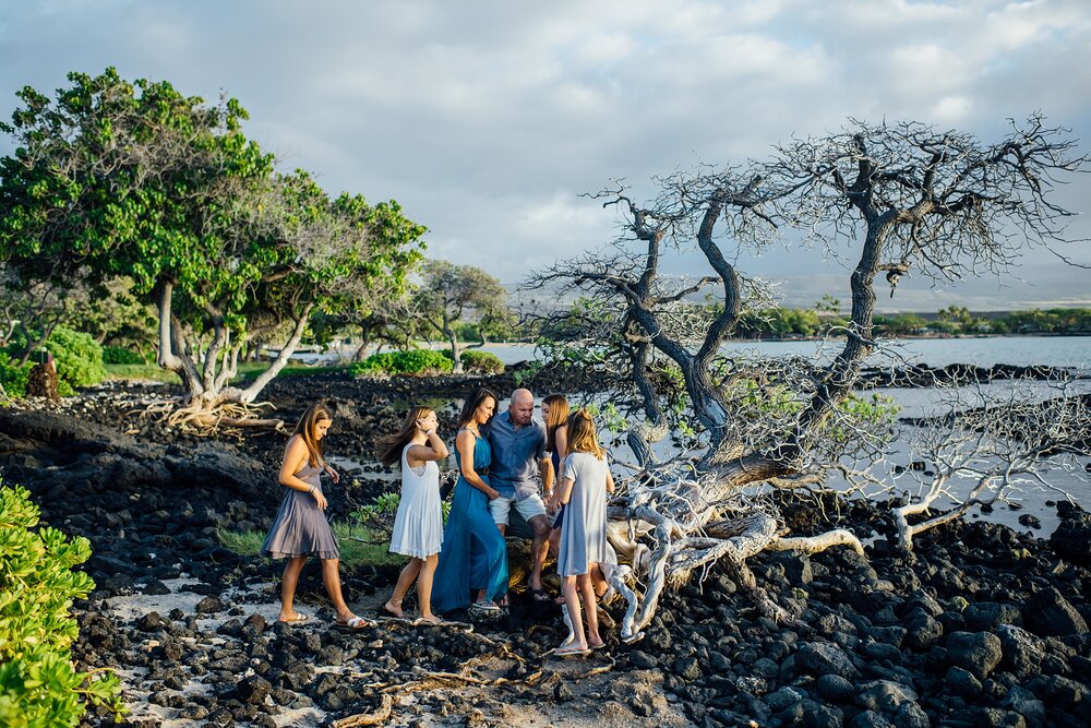 candid family moments at the driftwood in a Hawaii beach