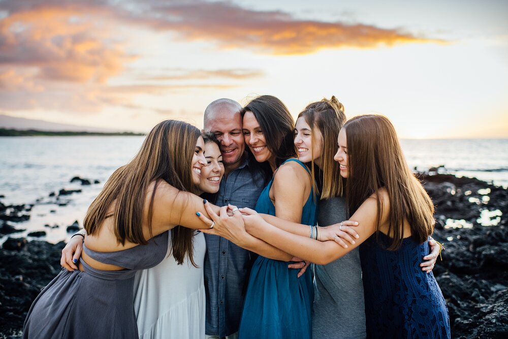 family snuggling each other at sunset during their Hawaii vacation 