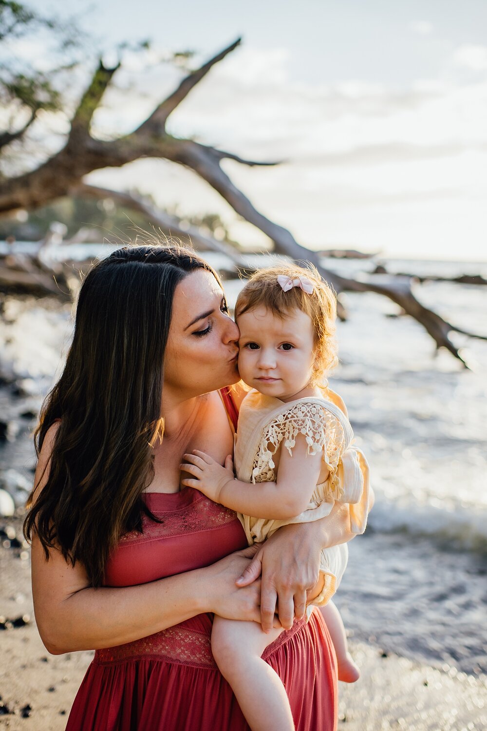 mom kissing her baby's cheeks by Hawaii family photographer