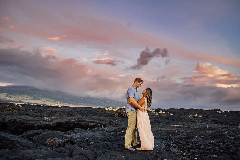 couple snuggling on lava rocks