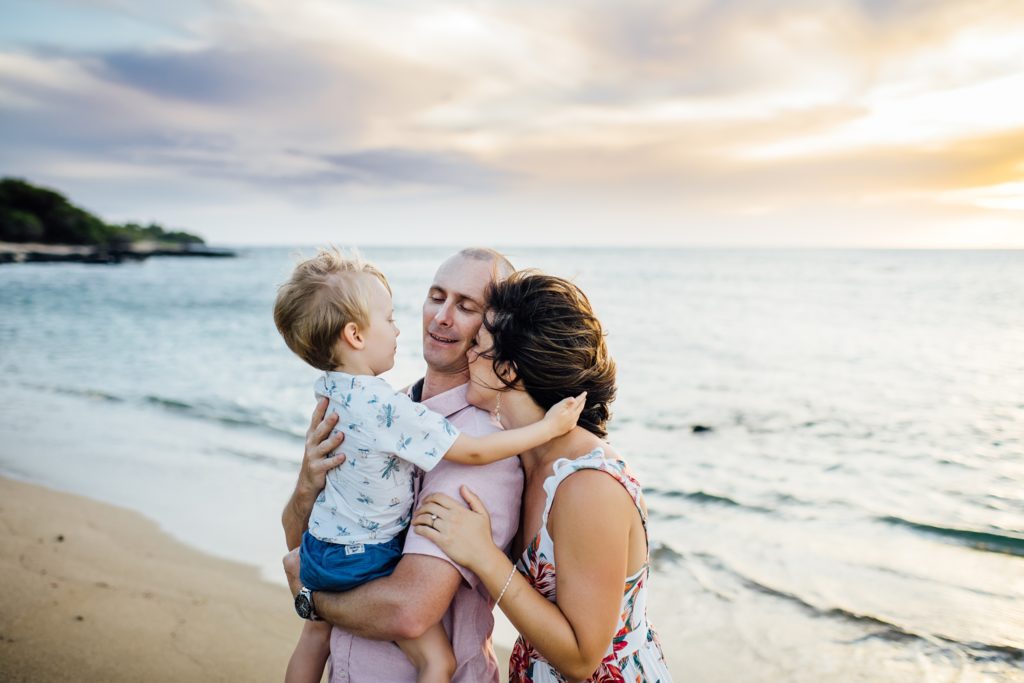family embracing each other on the beach in hawaii 