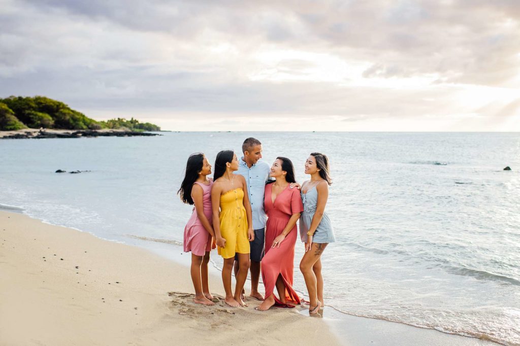 happy family standing on white sand beach by Hawaii photographer