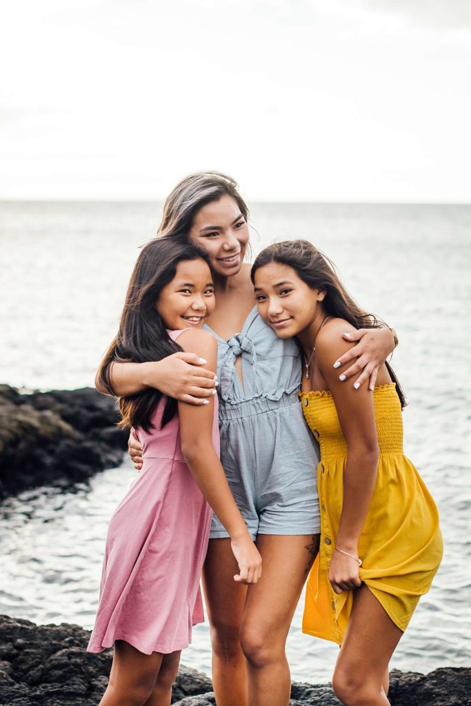 sweet beach moments with sisters by Hawaii family photographer