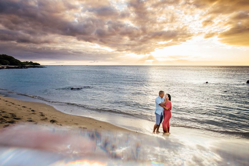stunning sunset behind the couple by Hawaii family photographer