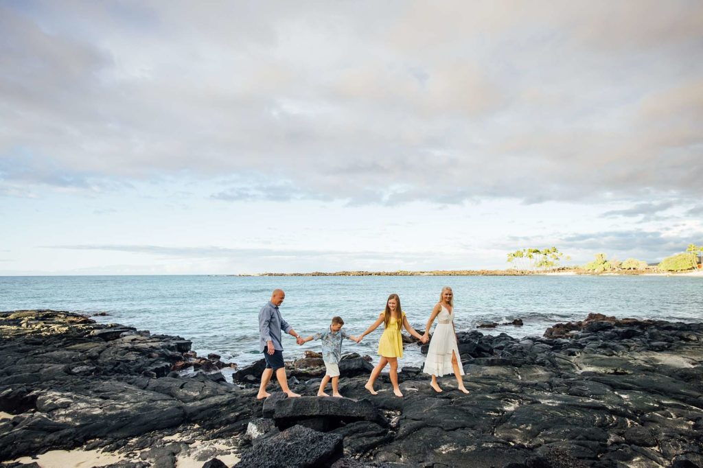 family walking on lava rocks in Hawaii