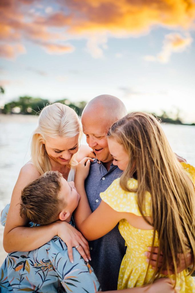 family embracing each other on the beach in hawaii by ann ferguson photography
