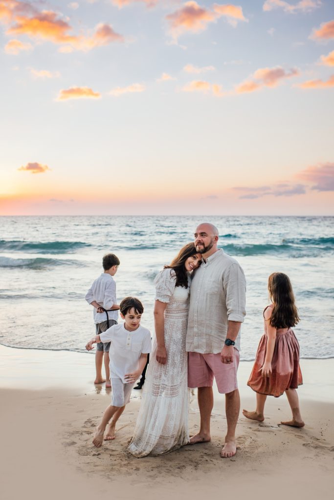 family on a beach in hawaii at sunset