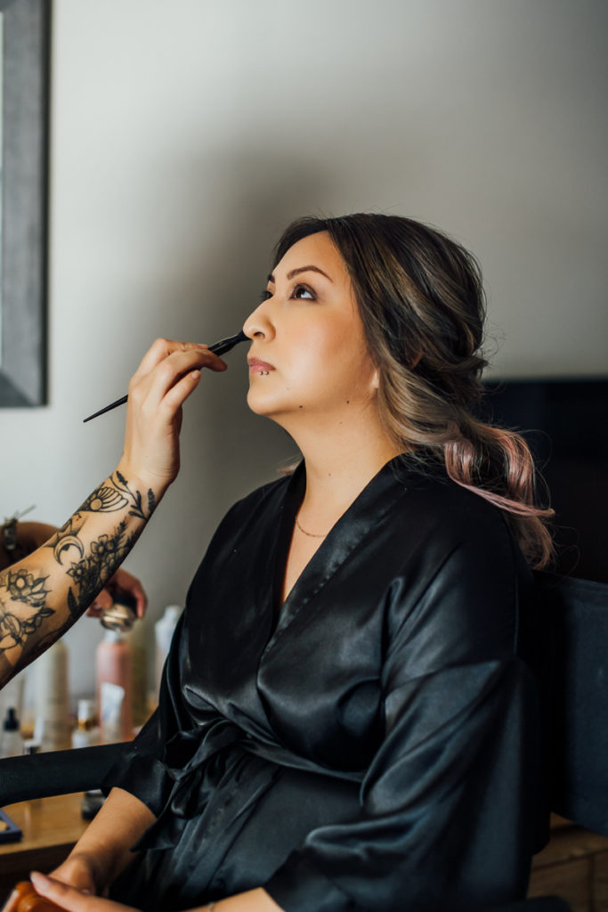 makeup artist applying makeup on bride's face