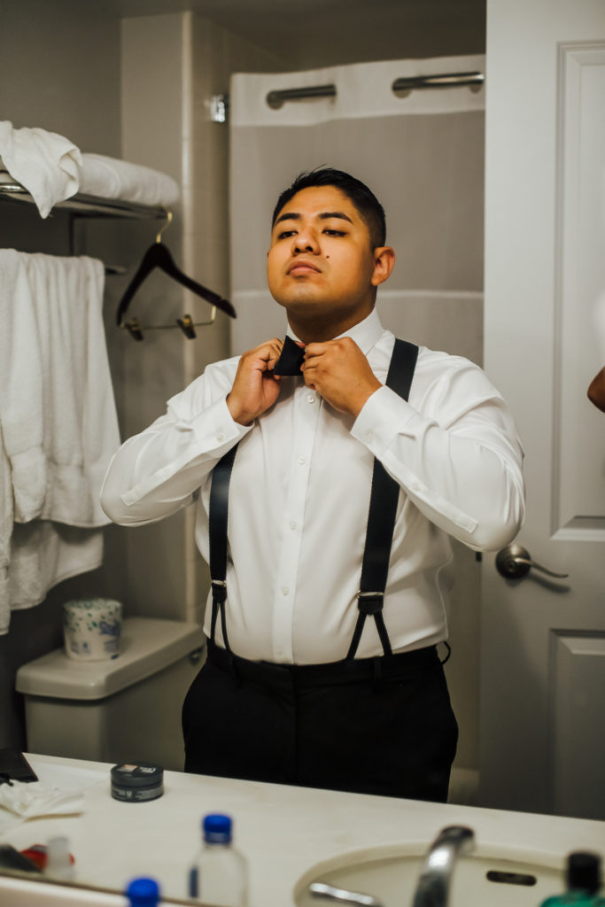 groom fixing his bow tie for his Big Island wedding