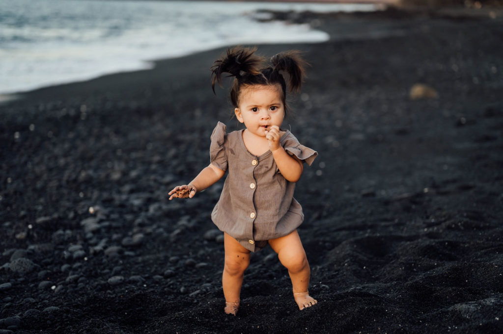 adorable little girl playing with sand by Big Island photographer