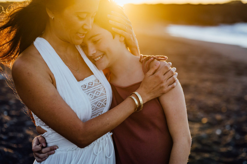 mom's warm hug under radiant sunset by Big Island photographer