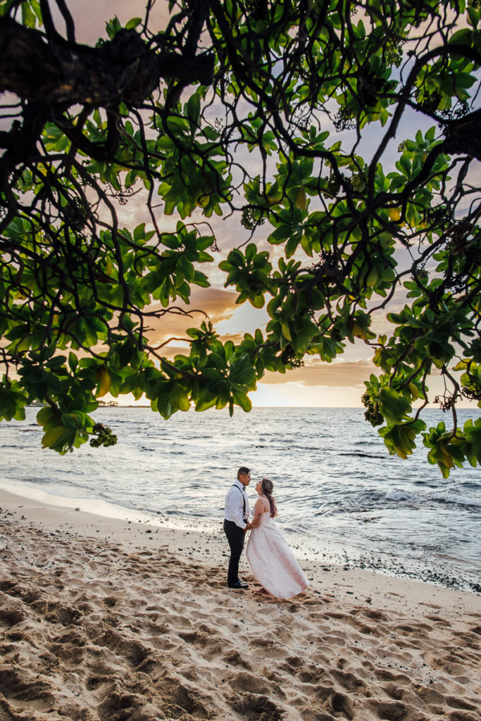 bride and groom looking at each other by the beach