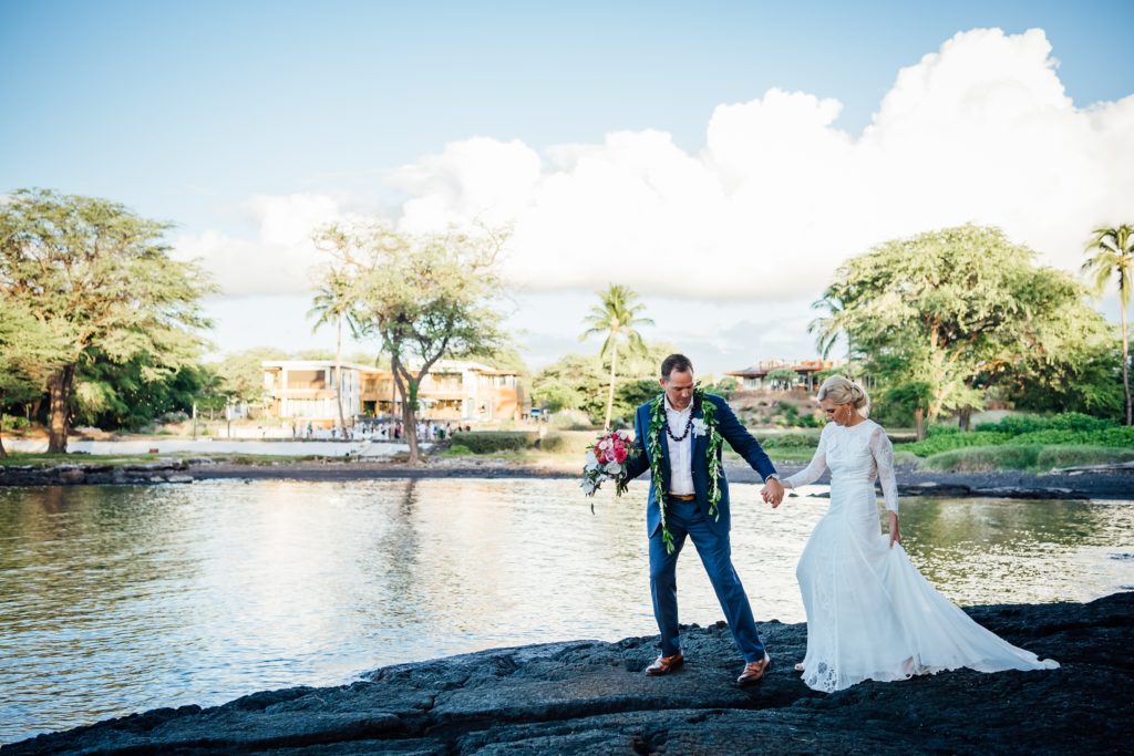 bride and groom walking on lava rocks field at this destination wedding in Hawaii