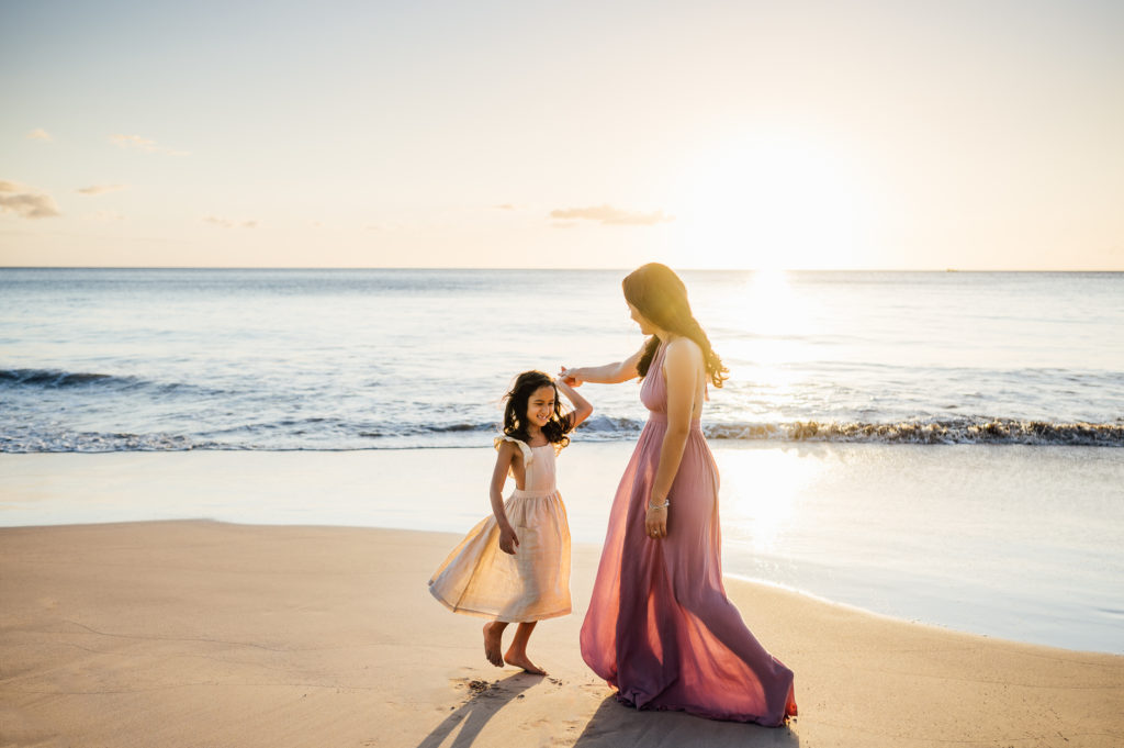 mom and daughter twirling in the sunset