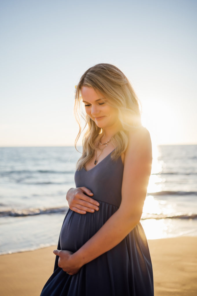 glowing pregnant wife under the stunning sunset by Kona photographer