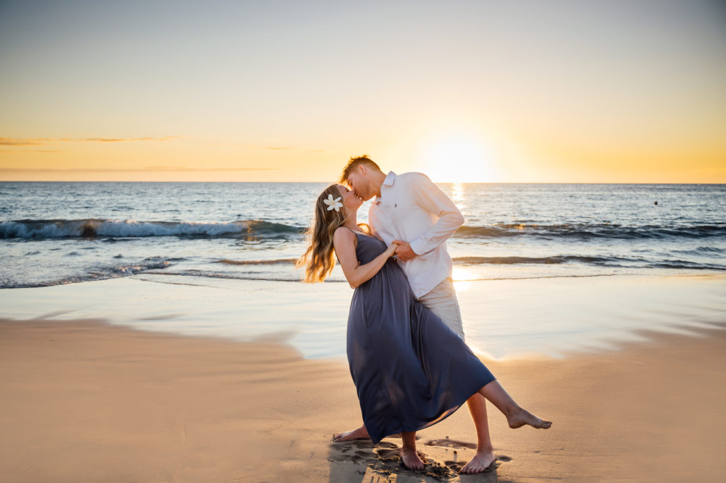 pregnant couple kissing under the golden sunset by Kona photographer