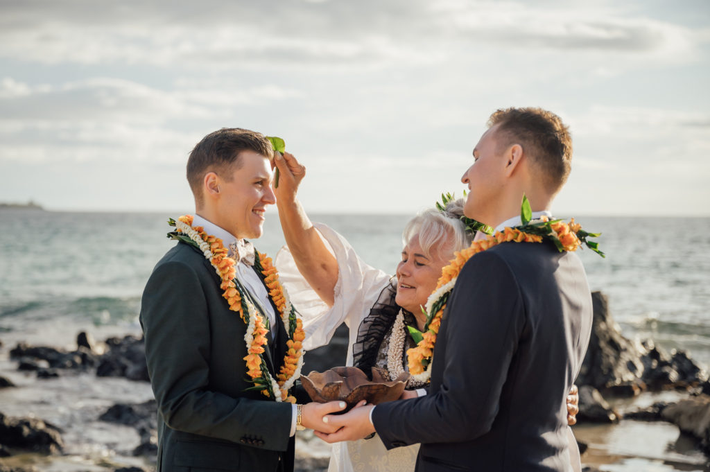 the couple and the officiant during a traditional Hawaiian ceremony 