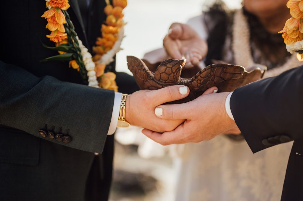 couple holding together the Koa bowl during wedding ceremony