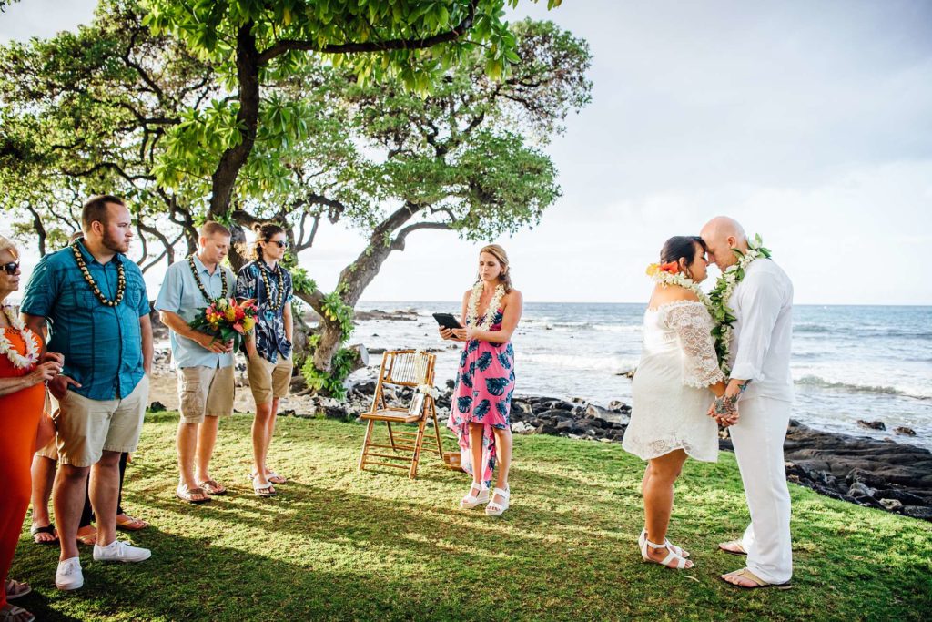bride and groom intimate moments with officiant and family during their Hawaii wedding