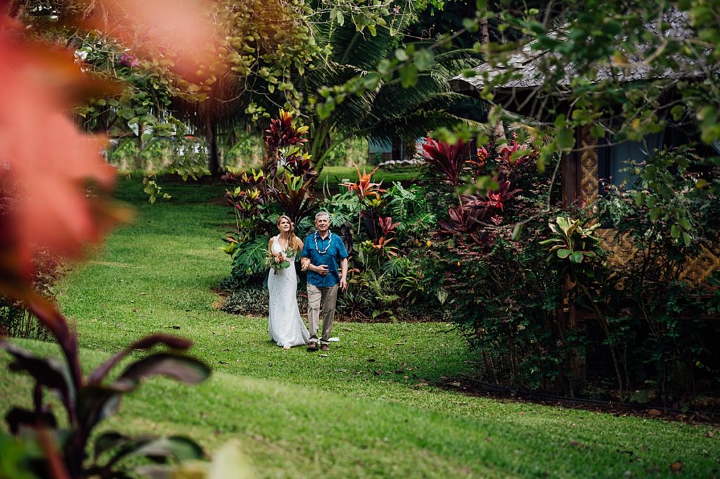 bride walks down the aisle with her dad for her Big island wedding