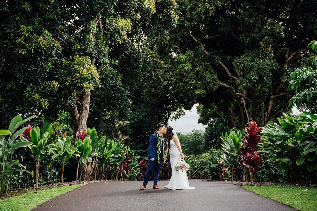 wedding photo of the bride and groom kissing under the trees during their Big Island wedding