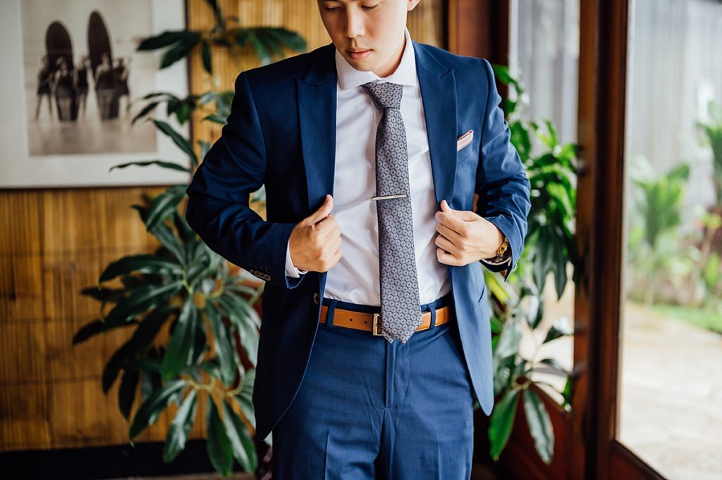 groom fixing his suit in place