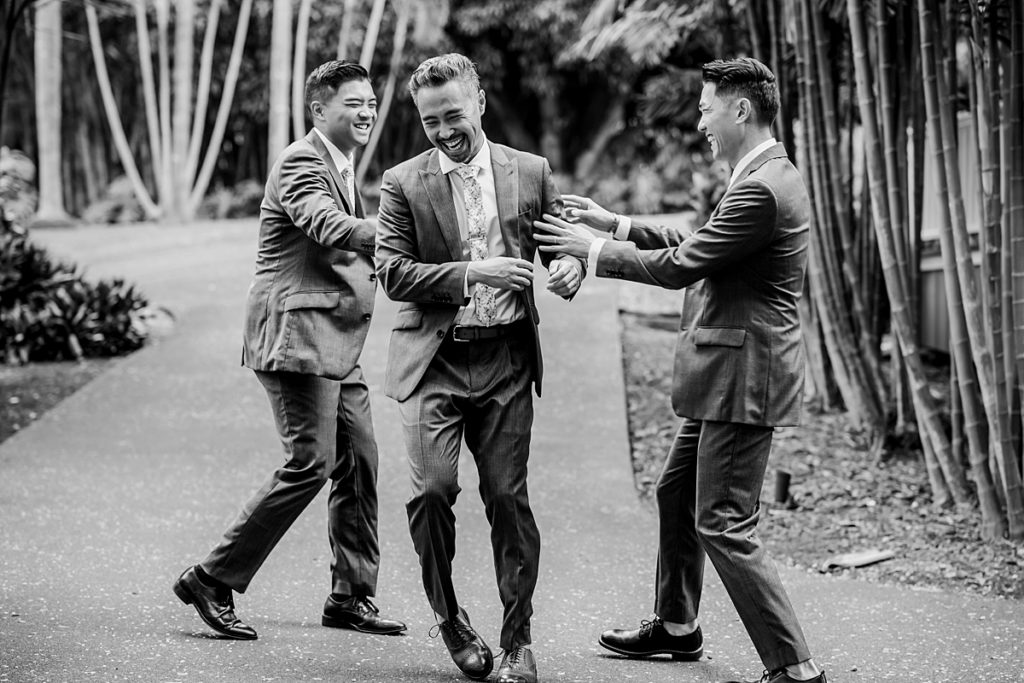 groom having fun with his groomsmen during his Hawaii wedding