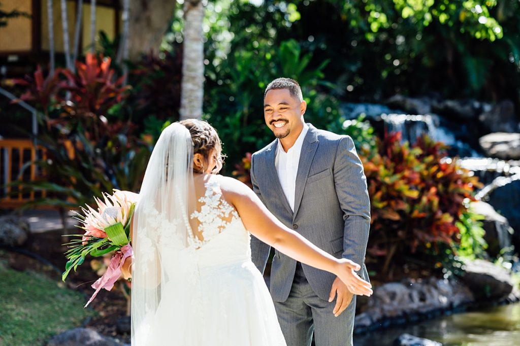 happy bride and groom during their first look at Fairmont Orchid