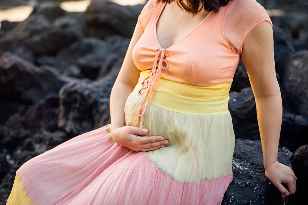 mom-to-be holding her belly by Hawaii photographer