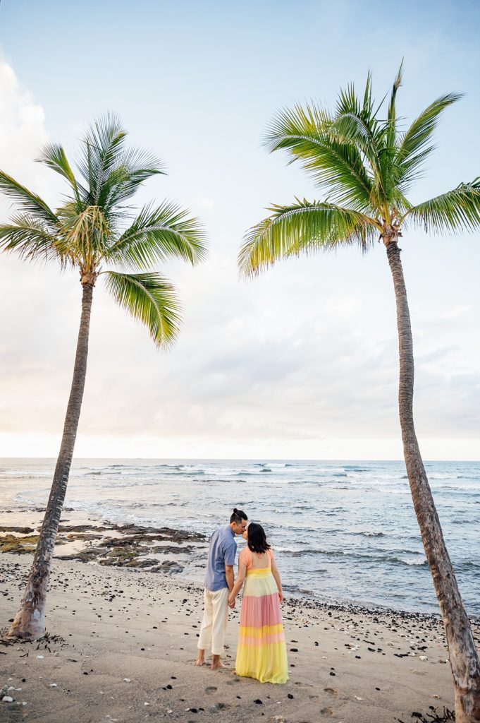 couple kissing under the coconut trees at Hawaii beach