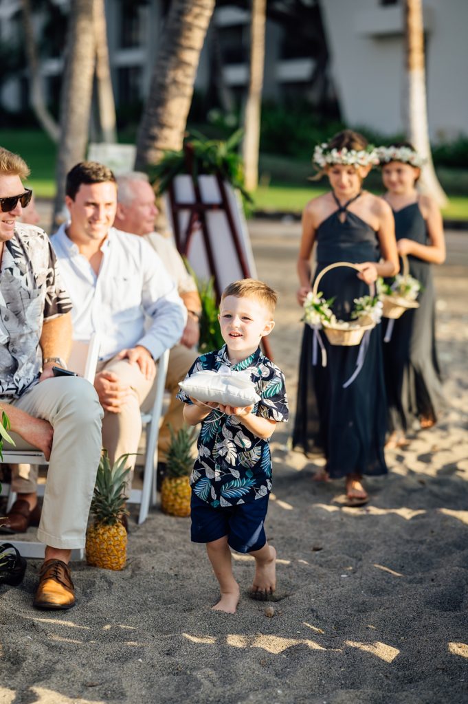 ring bearer marching down the aisle during a Mauna Lani wedding
