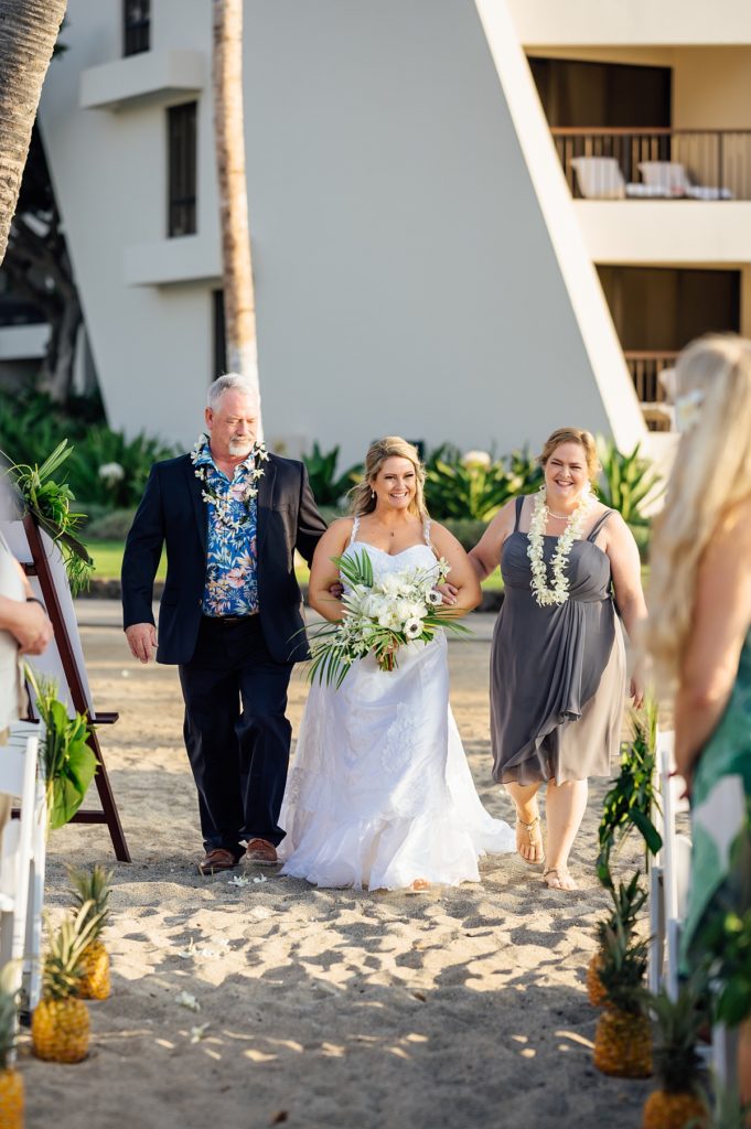 bride with her parents walking down the aisle during her Big Island wedding