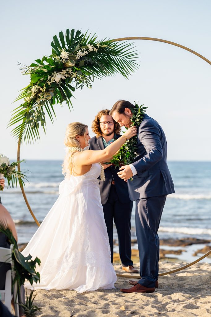 bride putting on the lei to the groom during their Big Island wedding ceremony