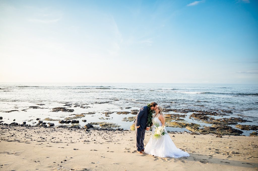 bride and groom kiss on a beach in the Big Island