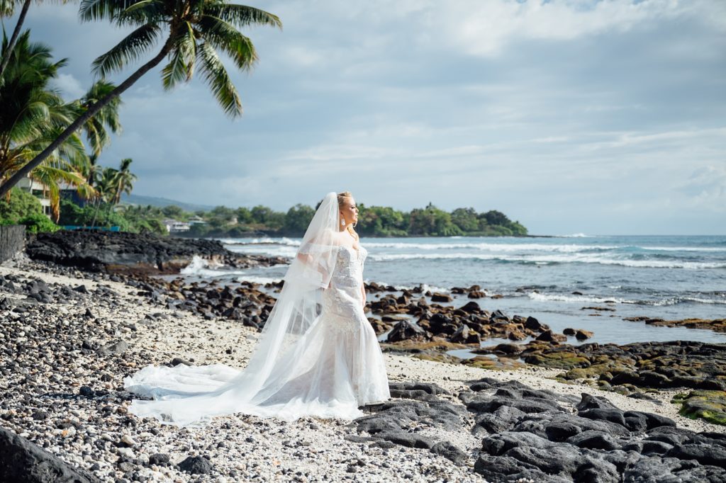 bride looking at the beach by wedding photographer in Hawaii