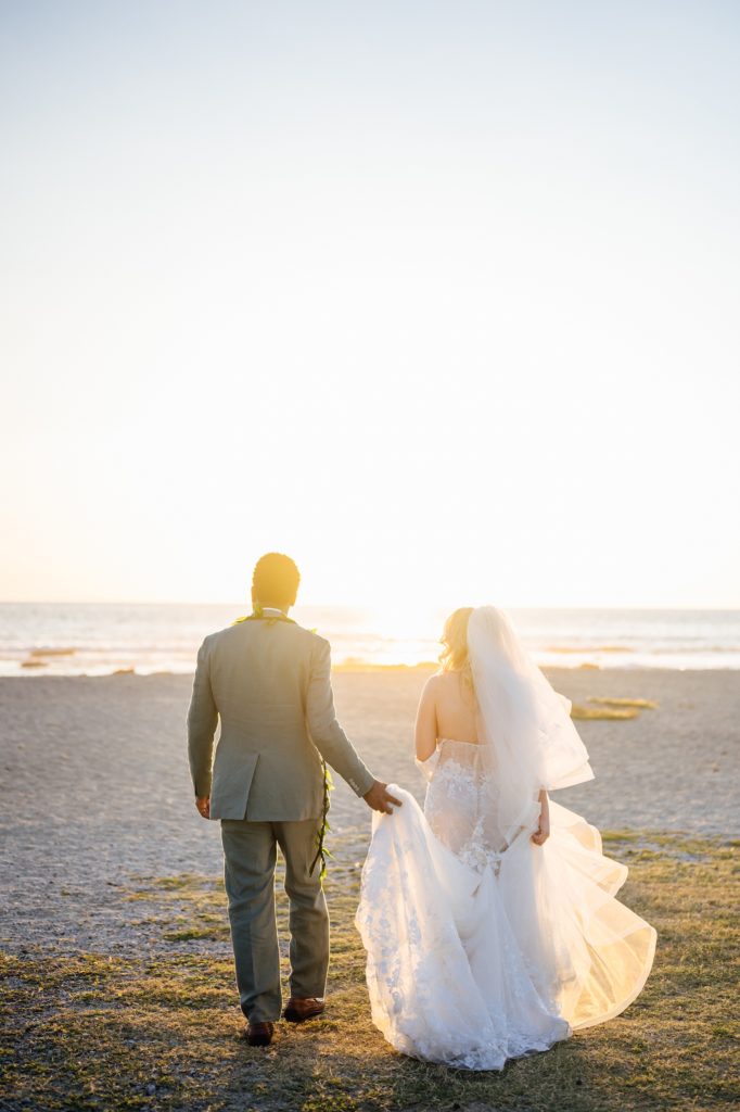 newlyweds under the stunning sunset by wedding photographer in Hawaii
