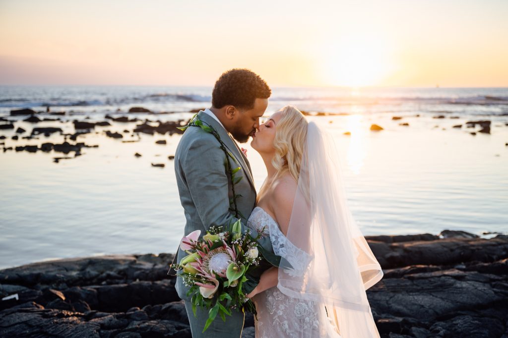 bride and groom kiss under the Hawaii sunset 