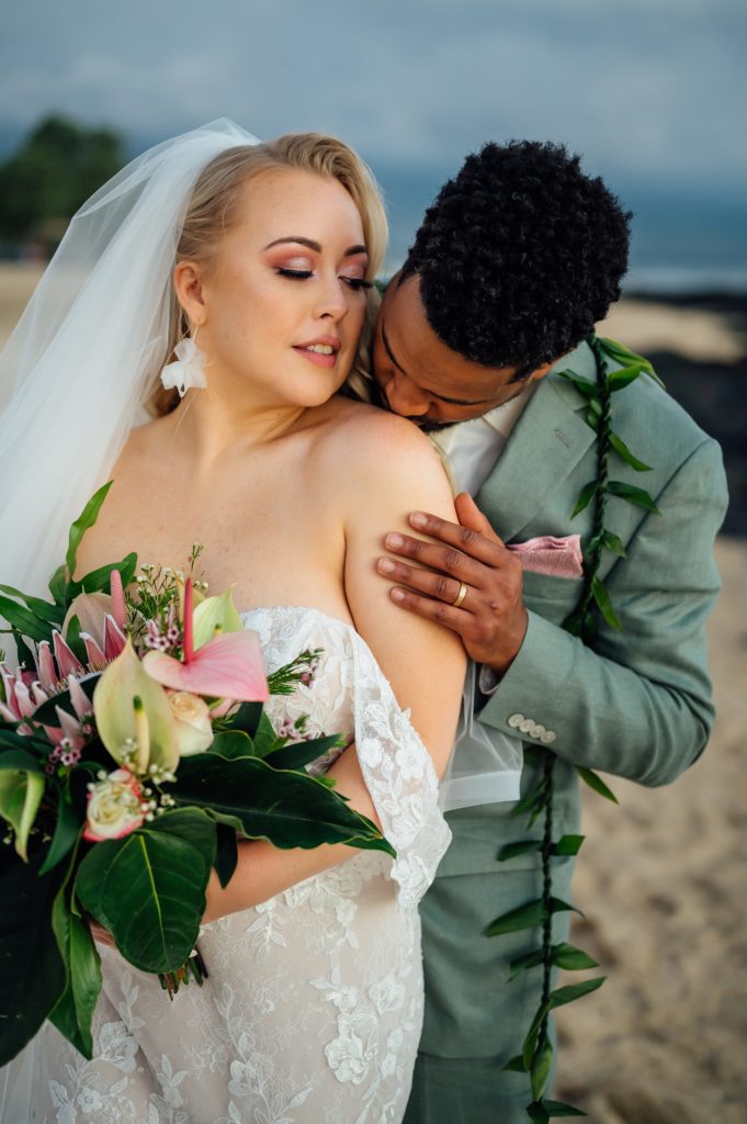 groom kissing bride's shoulder during their Hawaii wedding